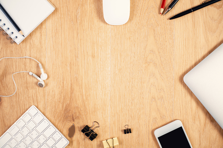 Top view of wooden desktop with electronic devices and stationery items. Mock upの写真素材