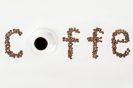 Closeup of white coffee cup and saucer on desktop with coffee beans. Selective focus, Mock upの写真素材