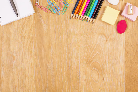 Top view of wooden desktop with bright colorful stationery items. Mock upの写真素材