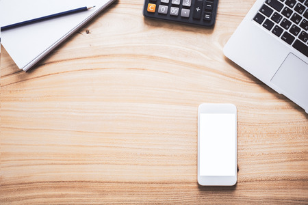 Natural wooden desktop with blank white smart phone, laptop keyboard, calculator and stationery items. Top view, Mock upの写真素材