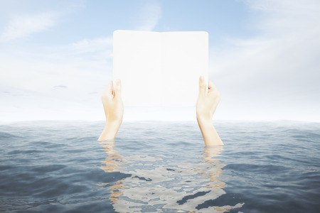 Hands in water holding blank white board on sky background. Mock upの写真素材