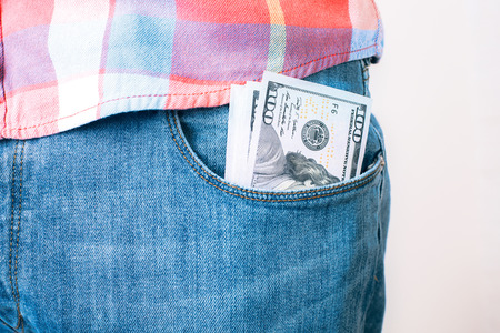Bribery and corruption concept with dollar banknotes in jeans pocket