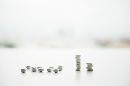 Closeup of white pill stacks on bright surface and blurry background