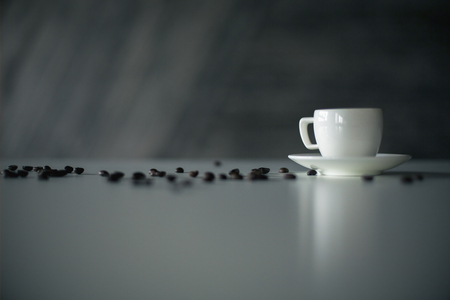 Ceramic coffee cup and beans on dark surface and backgroundの写真素材