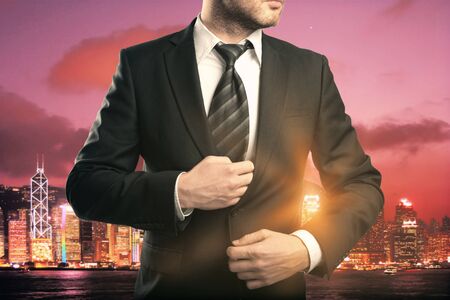 Businessman in suit and tie on red city background with abstract sunlightの写真素材
