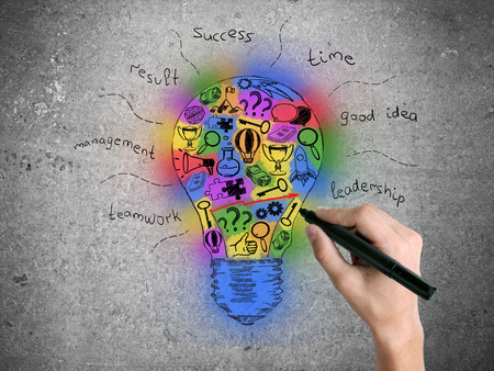 Hand drawing creative colorful lightbulb sketch on concrete wall. Idea conceptの写真素材