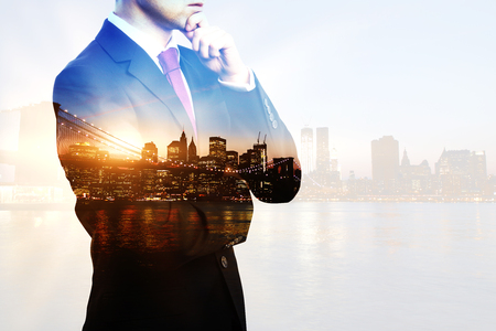Creative image of thoughtful businessperson in suit and tie on city background with sunlight. Double exposureの写真素材
