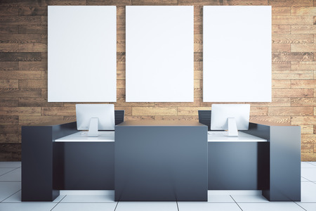 Modern black reception desk with two computer monitors and blank billboard in room with wooden wall and tile floor. Mock up, 3D Renderingの写真素材