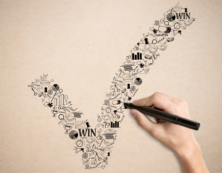 Male hand holding creative checkmark business sketch on light background. Success conceptの写真素材