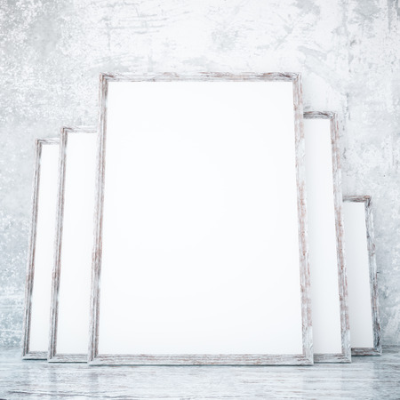 Room with several empty picture frames leaning on textured concrete wall. Mock up, 3D Rendering