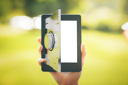 Close up of female hand holding digital tablet with abstract open bank vault door on blurry landscape background. Online banking concept. 3D Renderingの写真素材