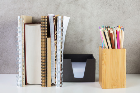 Closeup of book, notepads, pencils and other items on concrete wall background. Education conceptの写真素材