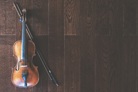 Top view of violin with bow on wooden floor with copy spaceの写真素材