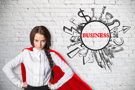 Attractive superwoman with red cape and business sketch on white brick background. Success conceptの写真素材