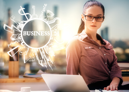 Attractive young woman using notepad on blurry city background with creative business sketch. Success conceptの写真素材