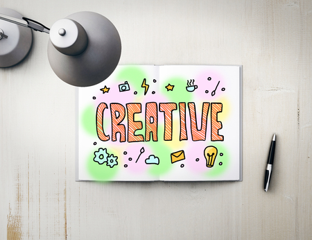 Top view of workplace with colorful sketch in notepad, pen and table lamp. Creative concept. 3D Renderingの写真素材