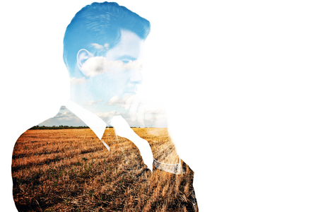 Thoughtful young man on field background. Double exposure.の写真素材