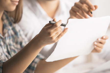 Close up portrait of attractive caucasian man and woman doing paperwork in modern office. Teamwork conceptの写真素材