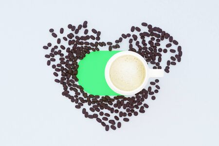 Top view of white surface with coffee cup and beans shaped as a heart. Coffee lovers concept. 3D Renderingの写真素材