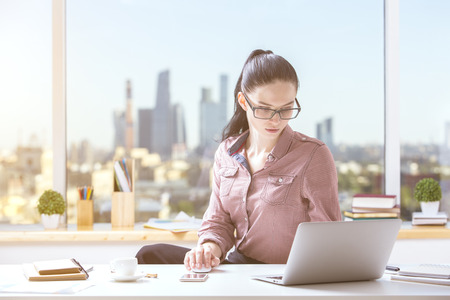 Portrait of beautiful girl using laptop at workplace. Project conceptの写真素材