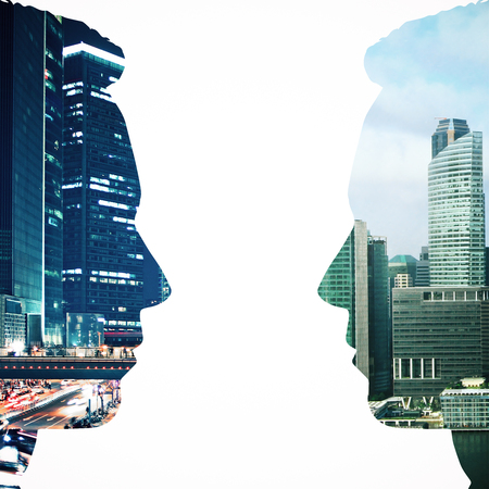 Two male head silhouettes facing each other on night city background. Communication concept. Double exposureの写真素材