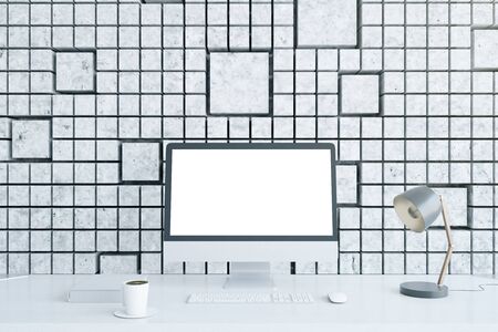 Designer desktop with blank white computer monitor, coffee cup, lamp and other items on patterned tile background. Mock up, 3D Renderingの写真素材