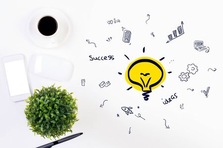 Top view of white office desktop with creative lamp sketch, coffee cup, blank smartphone and other items. Idea conceptの写真素材