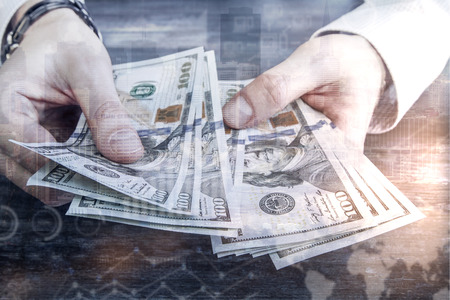 Male hands counting dollar banknotes on abstract city and business charts background. Income concept
