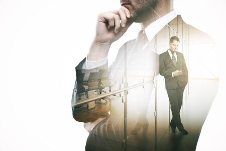 Thoughtful man using smartphone in modern office. Communication concept. Double exposureの写真素材