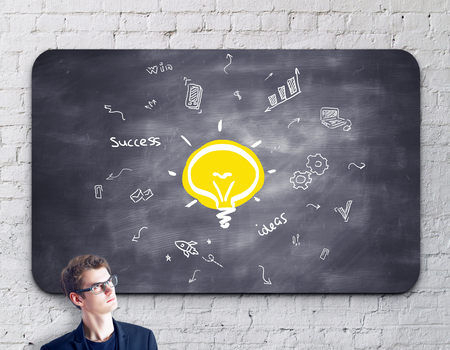 businessman thinking and drawing financial sketch on blackboardの写真素材