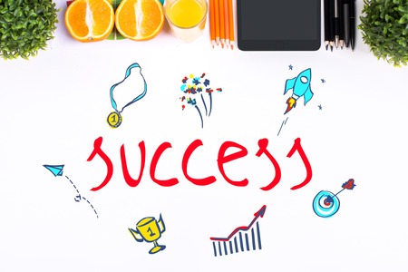 Top view of white office desktop with supplies, decorative plants, fruit and creative sketch with leadership icons. Success conceptの写真素材