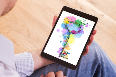Businessman holding tablet with creative key shaped business drawing. Wooden floor backgroundの写真素材