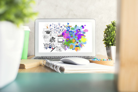 Front view of workplace with mathematical formulas and colorful sketch on computer screen. Creative...