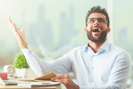 Handsome young businessman at workplace just understood a simple thingの写真素材