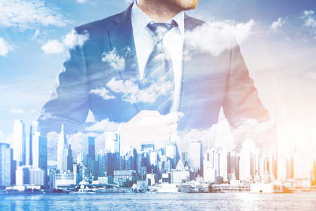 Thoughtful businessman in suit and tie on abstract city background with sunlight. Success conceptの写真素材