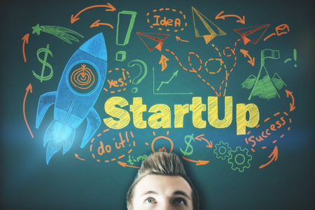 Thoughtful man on abstract green background with illuminated space ship sketch. Start up conceptの写真素材