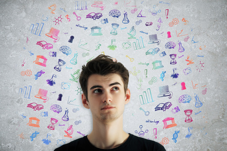 Thoughtful young boy with education related icons on concrete background