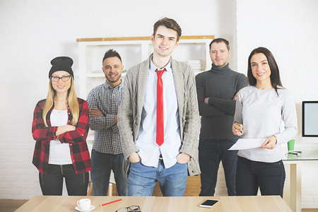 Front view of beautiful young european people in modern office with desktop. Teamwork conceptの写真素材