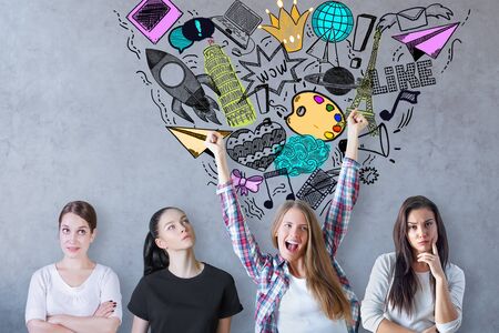 Thoughtful and cheerful young women on concrete background with creative sketch. Social media...