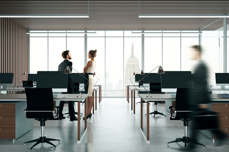 Blurry businesspeople in dark coworking office interior with city view. 3D Renderingの写真素材