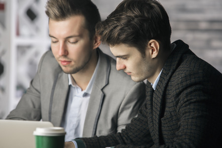 Close up portrait of two handsome european males at workplace. Teamwork conceptの写真素材