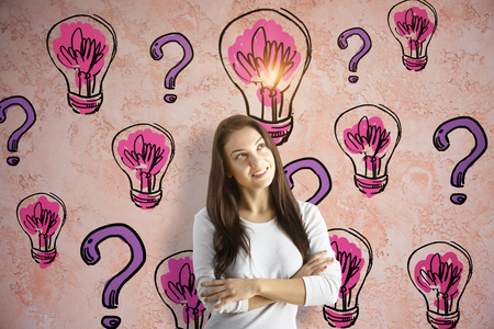 Portrait of cheerful young woman on textured background with drawn light bulbs and purple question marks. Confusion conceptの写真素材