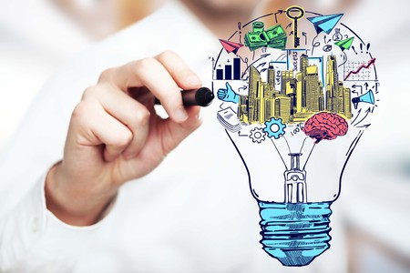 Close up of male hand drawing lamp with business icons. Brainstorming new ideas conceptの写真素材
