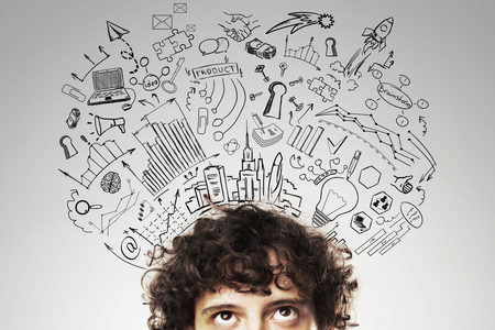 Portrait of thoughtful european businessman on grey background with business sketch. Brainstorm conceptの写真素材