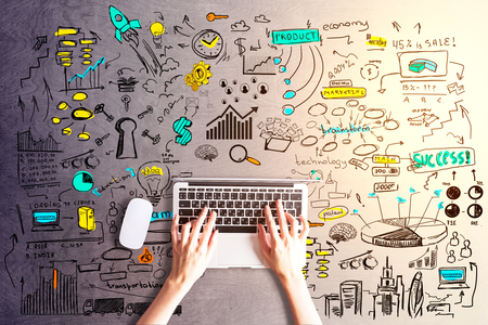 Top view of female hands using laptop on wooden background with colorful sketch. Online business conceptの写真素材