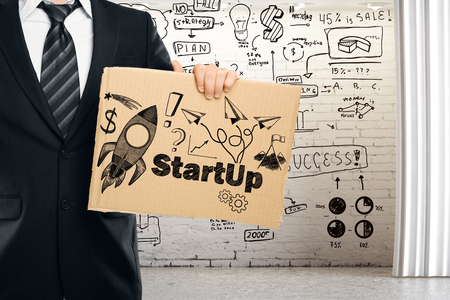 Businessman holding cardboard with creative spaceship sketch. Entrepreneurship concept. 3D Renderingの写真素材