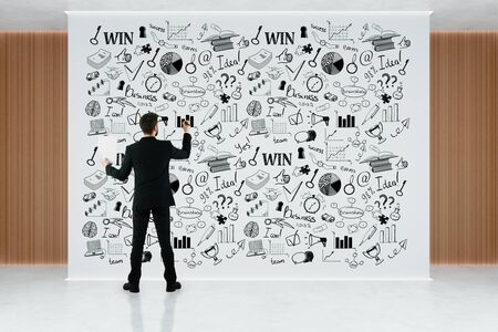Back view of young businessman in interior drawing sketch on billboard. Success concept. 3D Renderingの写真素材