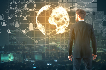 Back view of young businessman on city background with abstract business icons and charts. Accounting conceptの写真素材