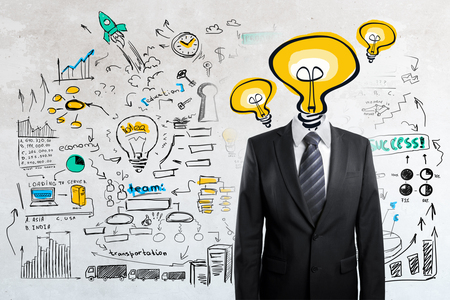 Light bulb headed businessman on concrete background with business sketch. Successful idea conceptの写真素材
