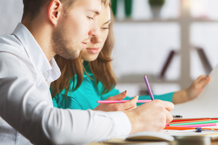 Close up portrait of caucasian man and woman doing paperwork at workplaceの写真素材